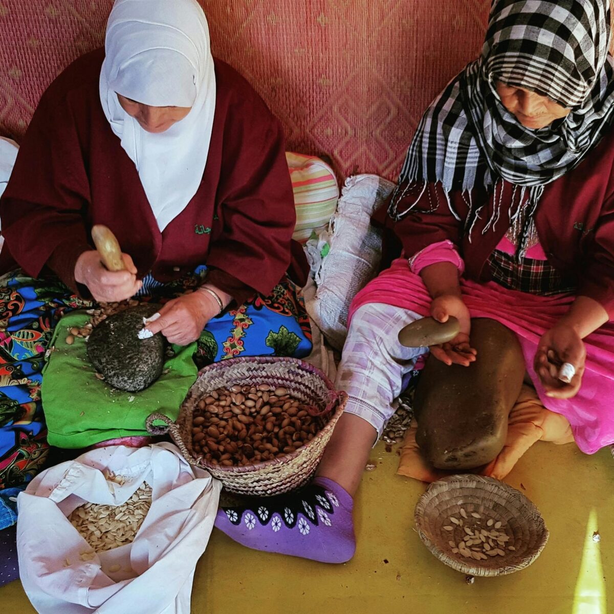 Deux femmes marocaines cassent des noix d'arganier