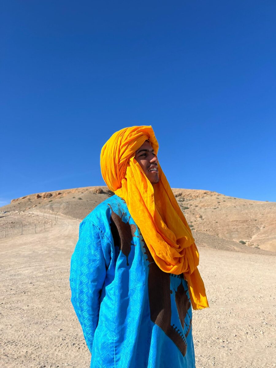 Homme berbère en bleu avec foulard jaune dans le désert - Pexels - Hauwa Eeyman