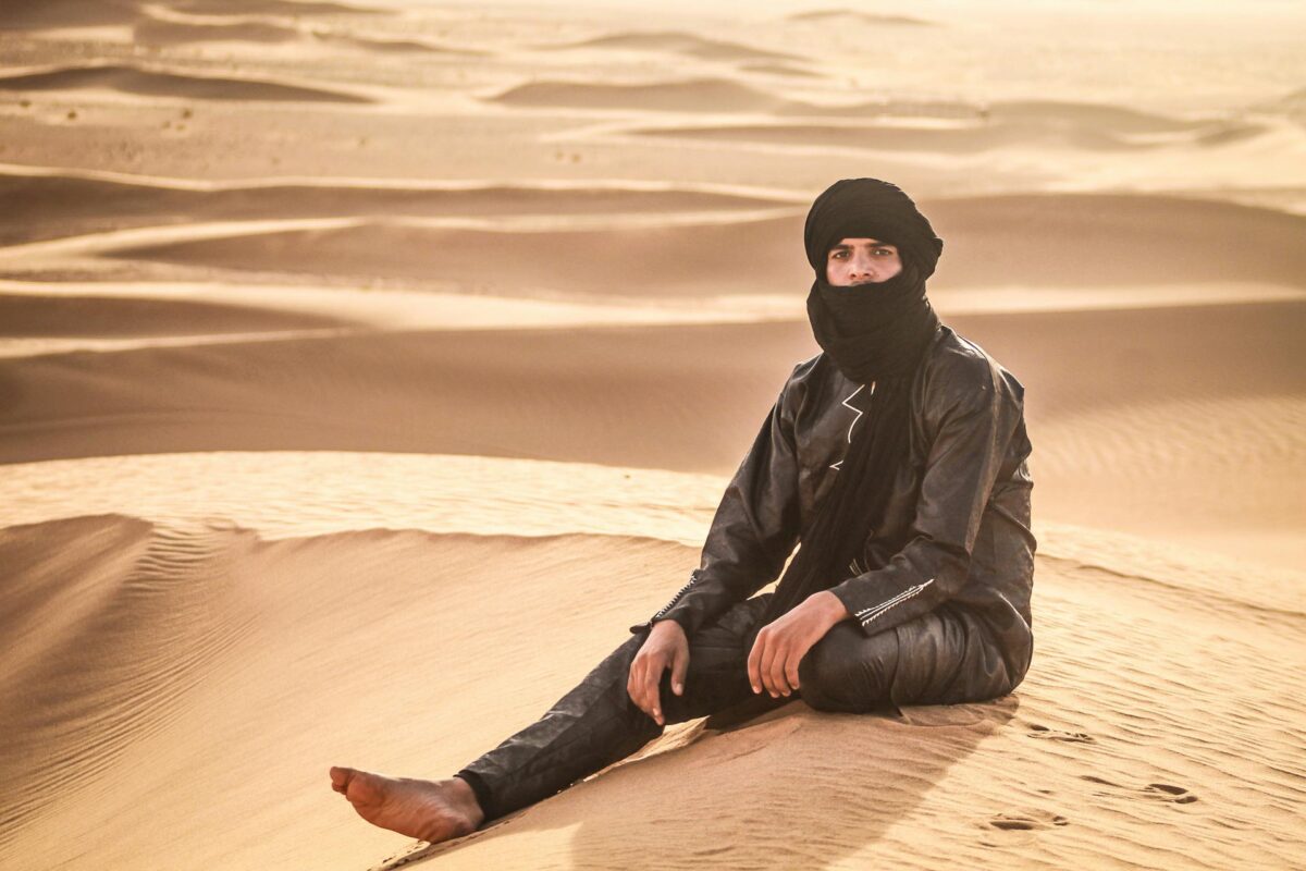 Nomade assise sur une dune dans le désert de Merzouga au Maroc